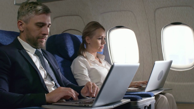 商务人士在飞机上使用笔记本电脑工作视频素材