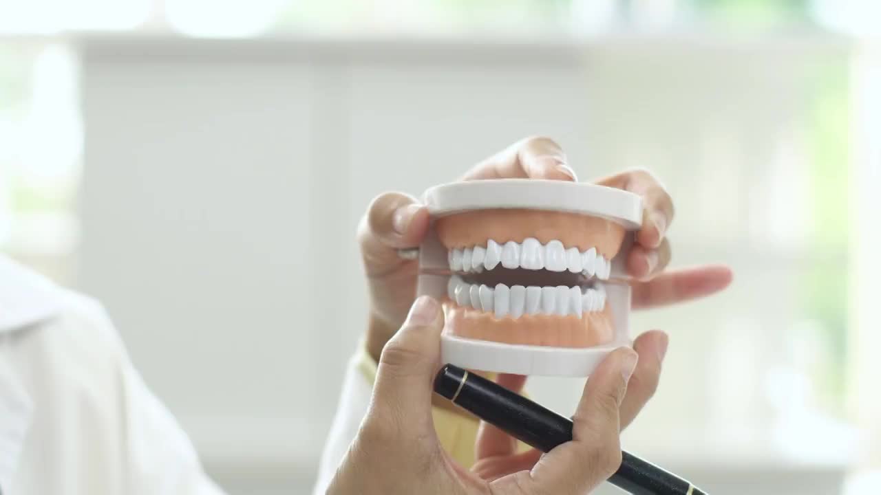 牙医在谈论假牙模型。视频素材