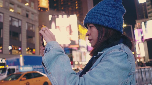 亚洲游客在时代广场拍摄夜晚的城市生活。视频素材
