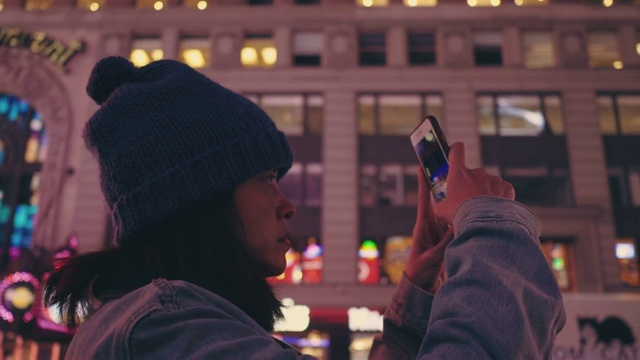 亚洲游客在时代广场拍摄夜晚的城市生活。视频素材