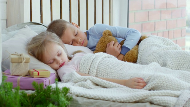 可爱的孩子们在圣诞节的早晨睡觉视频下载