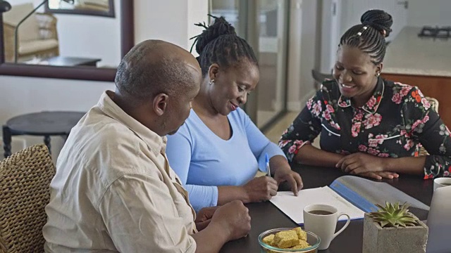 一对非洲成年夫妇在家里与理财顾问签订退休合同视频下载