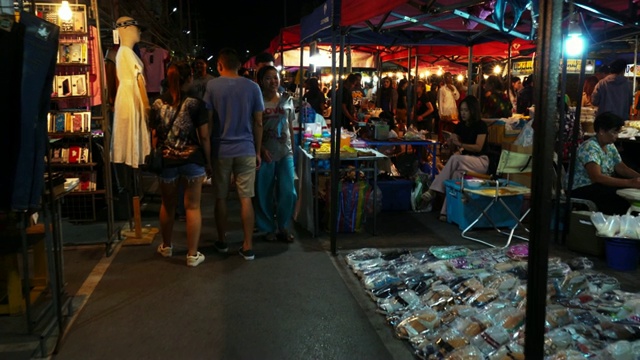 夜市夜景，身份不明的人，当地居民和游客。人们购买当地的食物和商品。视频下载