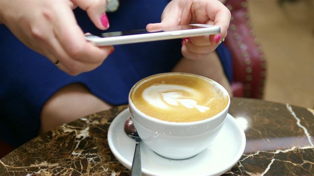 一个女人在拍桌上的拿铁咖啡，画面是4k慢镜头60fps视频下载