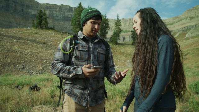 一对沮丧的夫妇在山上检查手机信号/美国犹他州的Timpanogos山视频下载