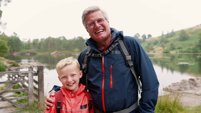 爷爷和孙子笑着站在湖边，近处，英国湖区视频素材