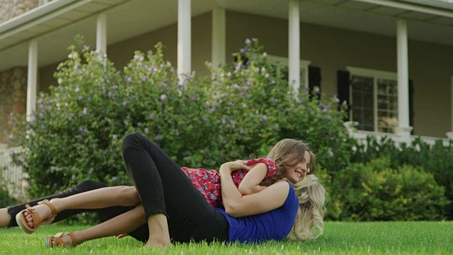 慢镜头拍摄的女孩跑进母亲的怀抱，坐在草坪/愉快的Grove，美国犹他州视频素材