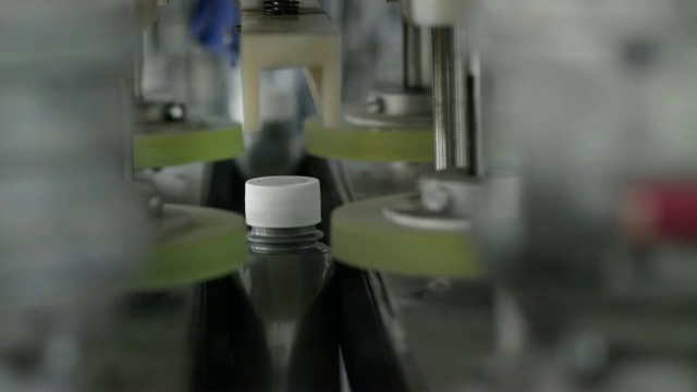发动机润滑油生产线上的灰色塑料瓶盖自动关闭装置视频下载