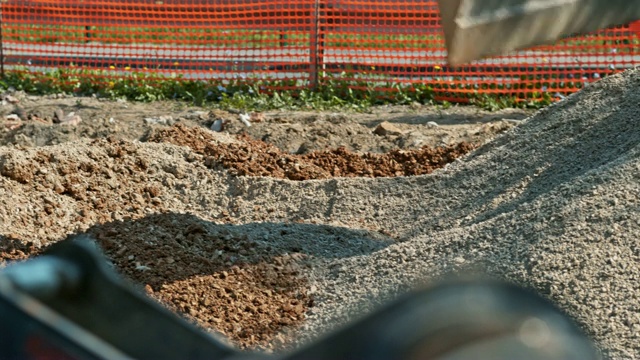 在施工现场撒碎石的挖掘机斗视频素材