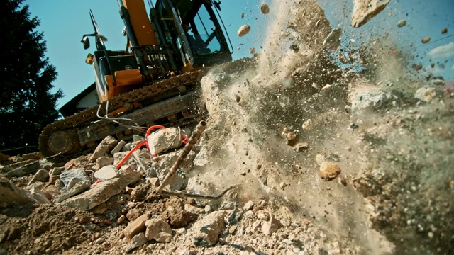 SLO MO建筑垃圾从挖掘机中释放出来，落在阳光下的一堆上视频素材