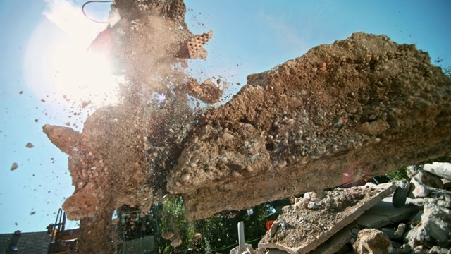 SLO MO挖掘机在阳光下处理释放的施工垃圾视频素材