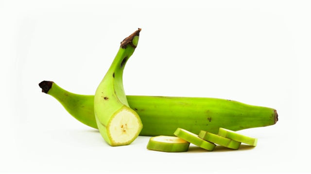一整个绿色烹饪大蕉，切一半的香蕉。在转盘上旋转。孤立在白色背景上。特写镜头。宏。视频下载