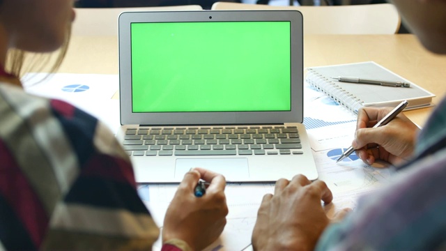 两个女商人在绿色的笔记本电脑屏幕上交谈视频素材