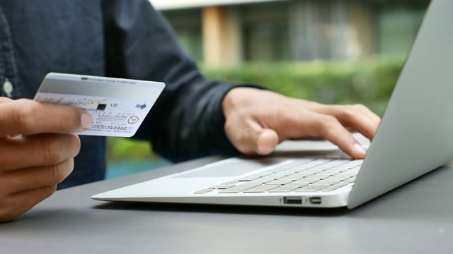 一名男子用信用卡在笔记本电脑上购物视频素材