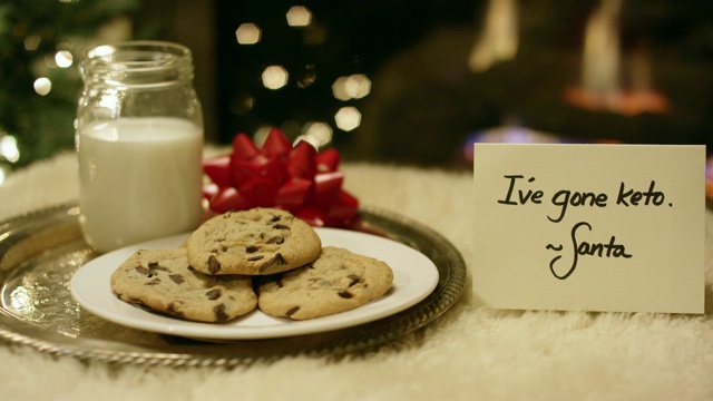 生酮圣诞:圣诞老人在平安夜的壁炉旁放一张写着“我生酮了”的卡片，礼貌地拒绝了牛奶和饼干视频素材