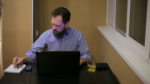 穿着衬衫，蓄着胡子的疲惫商人在深夜办公室里笔记本电脑开始变得紧张和愤怒视频下载