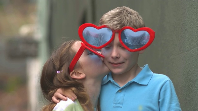 一对戴着心形太阳镜的兄妹对着镜头拥抱微笑视频下载