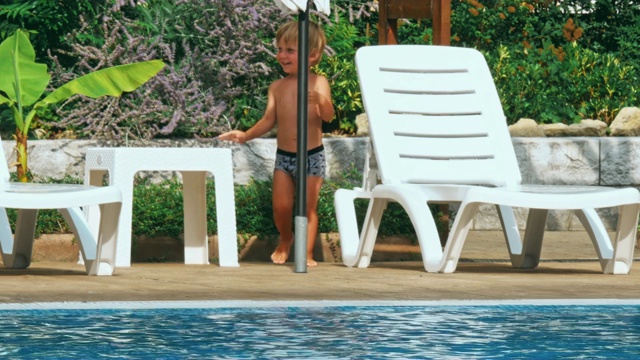 泳池边快乐的小男孩。视频下载