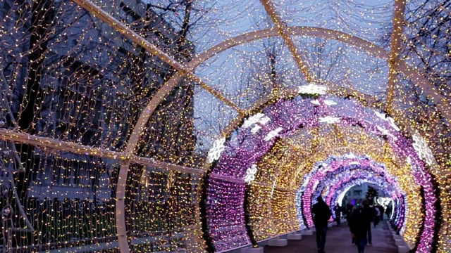 彩色的灯拱门模糊的灯闪烁着明亮的颜色。圣诞节和新年假期的背景视频素材