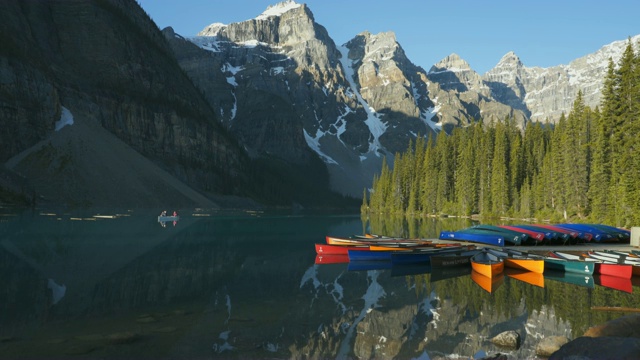 游客在加拿大班夫np的冰碛湖上划着独木舟视频素材