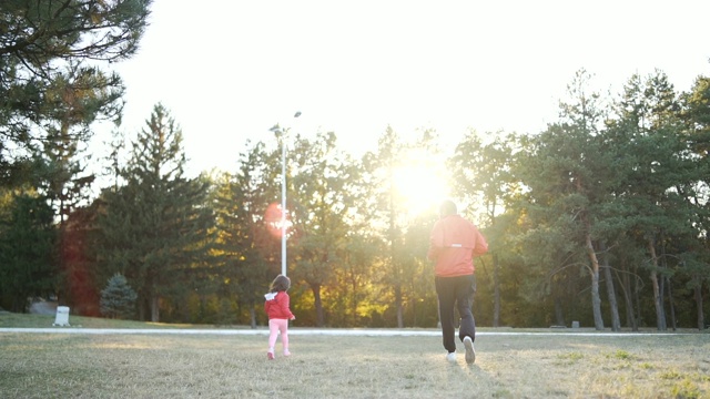 爸爸和小女儿在公园里跑步视频素材