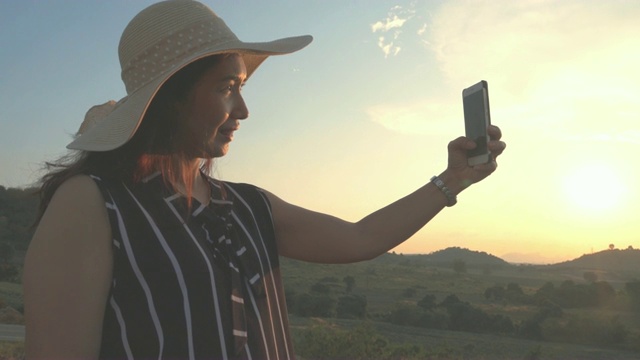 4K:一名女子在山上用智能手机拍摄美丽的景色视频下载