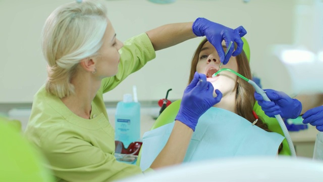 牙医用牙科工具检查病人的牙齿。医生和病人视频素材