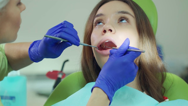 近距离观察牙科医生用口腔镜检查病人的牙齿视频素材