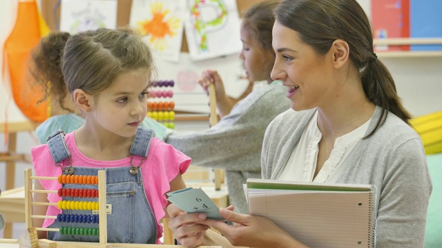 快乐的女幼儿园老师帮助学生学习数学卡片视频素材