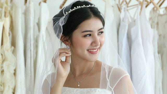美丽的新娘把她的珠宝和婚礼耳环视频素材