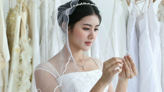 美丽的新娘把她的珠宝和婚礼耳环视频素材