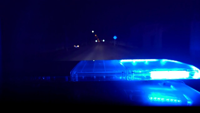 驾驶夜间有红蓝警灯闪烁的警车视频素材