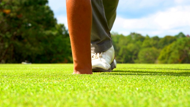 高尔夫球手把高尔夫球洞冠军的比赛，球员打高尔夫球场在日落是美丽的自然。视频素材