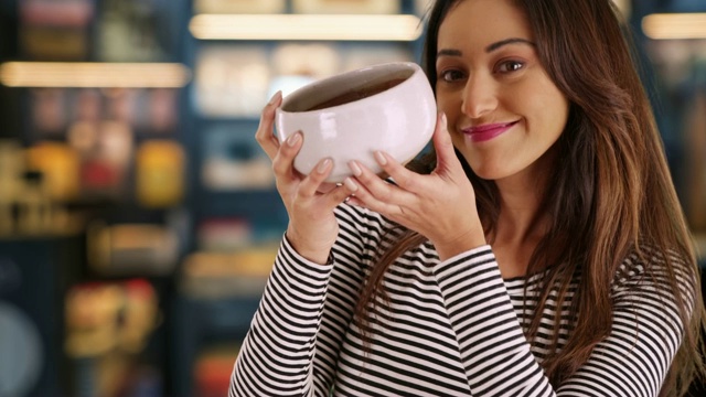 微笑的拉丁妇女肖像在商店拿着陶瓷碗视频下载