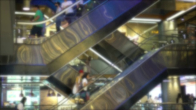 人们在使用商场里的自动扶梯，视线模糊视频素材