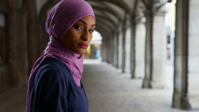 年轻美丽的穆斯林妇女戴着头巾摆姿势拍照视频下载