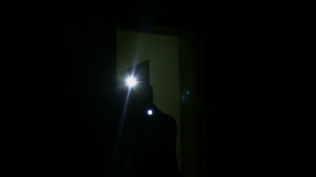 男性罪犯拿着手电筒来到黑暗的公寓，私人财产保安视频下载