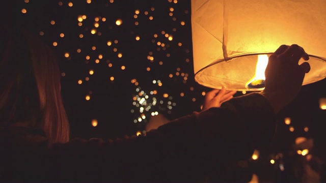 快乐的年轻女子在元宵节晚上拿着点燃的纸灯笼视频素材