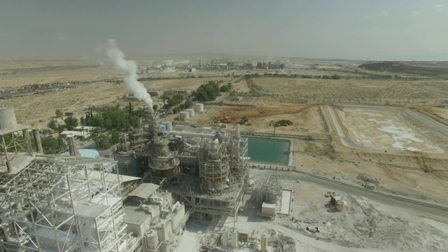 空中/工业工厂的烟囱在沙漠中吹着烟视频素材