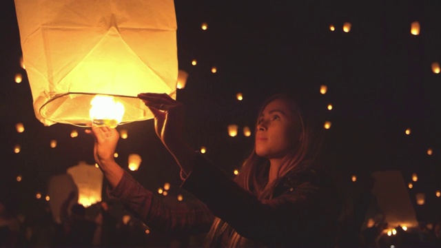 快乐的年轻女子在元宵节晚上拿着点燃的纸灯笼视频素材