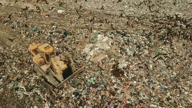 鸟瞰图-成千上万的黑鸢(Milvus移民)在一个巨大的垃圾堆上觅食，而重型车辆和垃圾车带来了更多的垃圾/杜达伊姆垃圾场，以色列南部视频素材