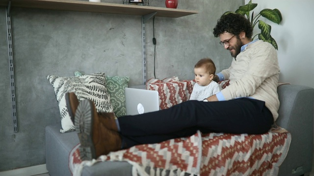父亲和小儿子在电脑上看动画片视频素材