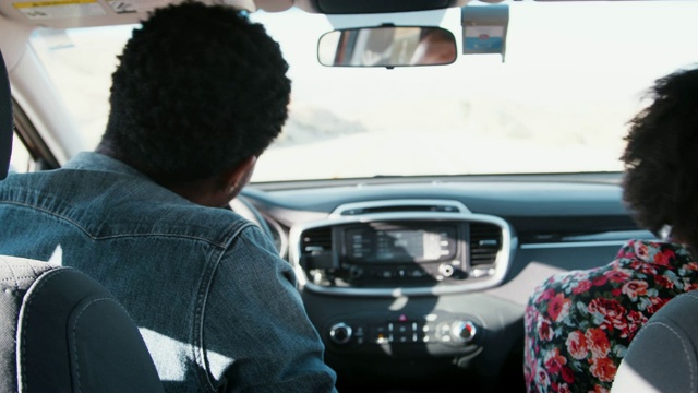 年轻的黑人夫妇在车里跳舞，他们开车时，后视镜视频素材