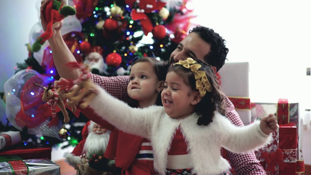 爸爸和他的女儿们，在圣诞树上视频素材
