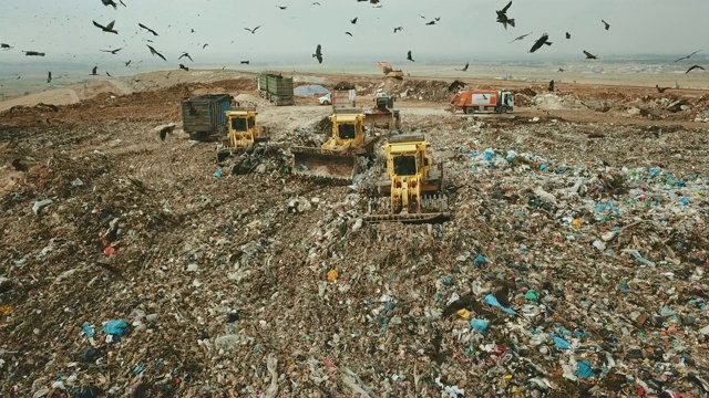 鸟瞰图-成千上万的黑鸢(Milvus移民)在一个巨大的垃圾堆上觅食，而重型车辆和垃圾车带来了更多的垃圾/杜达伊姆垃圾场，以色列南部视频素材