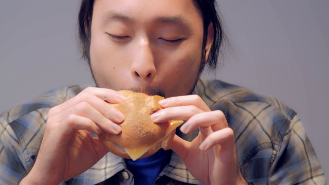 一个人饿着吃汉堡包。视频素材