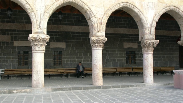 土耳其东南部，一位库尔德老人坐在Diyarbakır大清真寺的长凳上休息视频下载