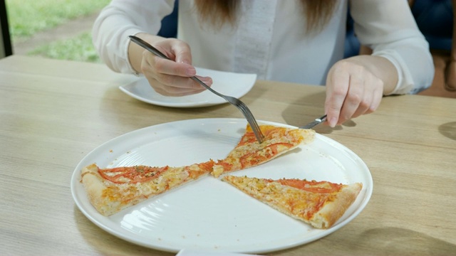 披萨店。一个年轻女子从盘子里拿了一片披萨视频下载