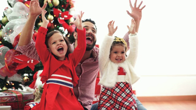 爸爸和女儿们在圣诞树旁庆祝视频素材