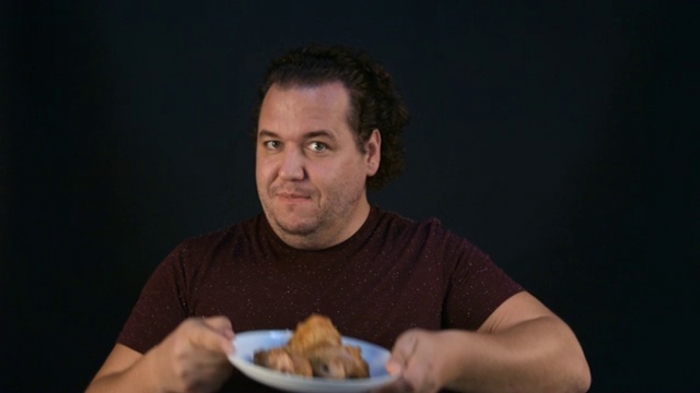 那个胖子吃肉吃得很贪婪。视频素材
